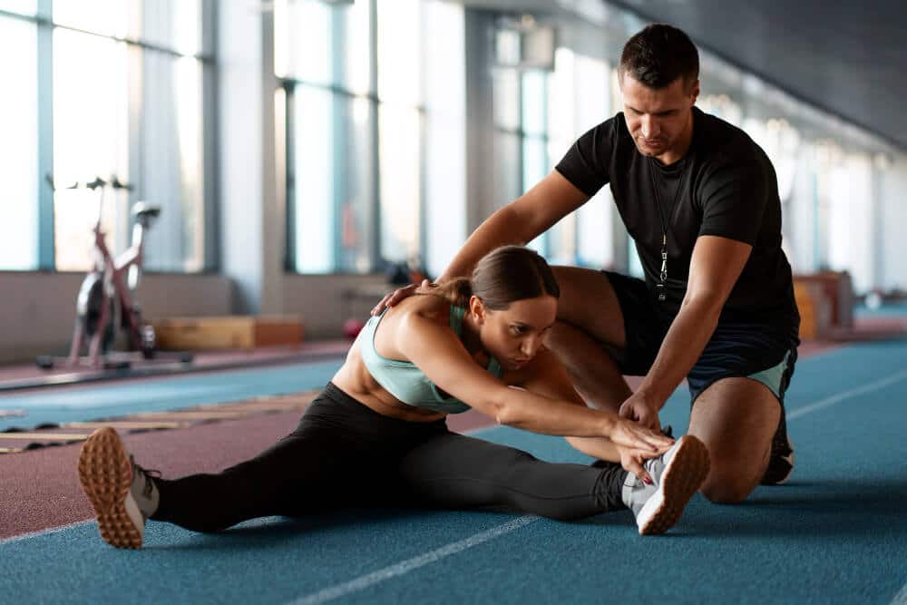 Atleta sendo orientada por seu treinador, ilustrando a importância da quiropraxia para atletas